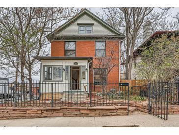 Charming brick two-story home featuring a well-manicured front yard and inviting entrance at 1474 Clayton St, Denver, CO 80206