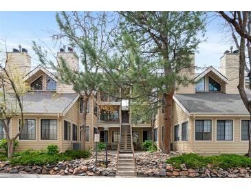 Charming condo with mature trees, neutral color scheme, and rock landscaping at 4824 E Kentucky Ave # F, Denver, CO 80246