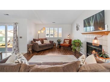 Inviting living room features a cozy fireplace, wood floors, and stylish decor at 8408 Everett Way # B, Arvada, CO 80005