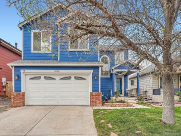 Charming blue two-story home with a large front lawn, white garage door, and mature tree at 8793 Cloverleaf Cir, Parker, CO 80134