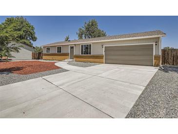 Charming single-story home with a well-maintained yard and long driveway leading to an attached garage at 16273 E Brown Pl, Aurora, CO 80013