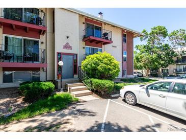 Two-story apartment building with updated red trim and lush landscaping at 12131 Melody Dr # 101, Denver, CO 80234