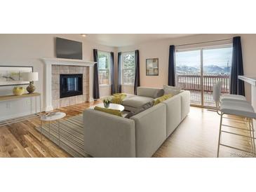 Cozy living room with fireplace, large sliding glass doors to deck and mountain views at 16645 W 2Nd Ave, Golden, CO 80401