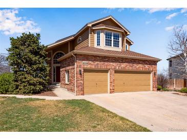 Charming brick home with a two-car garage and well-maintained lawn at 9239 Erminedale Dr, Lone Tree, CO 80124