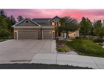 Charming two-story home with stone accents, a three-car garage, and a well-maintained lawn at 20510 Oakbrook Ln, Parker, CO 80138