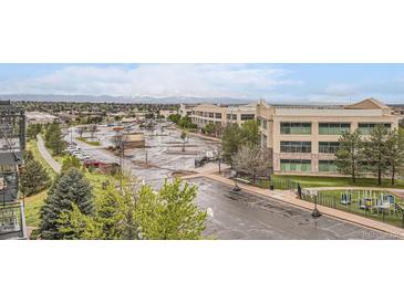 A view of the building's exterior with parking and greenery surrounding the property at 10176 Park Meadows Dr # 2403, Lone Tree, CO 80124
