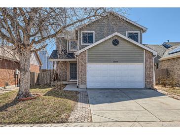 Charming two-story home with brick accents, a well-maintained lawn, and a two-car garage at 12144 Newport Dr, Brighton, CO 80602