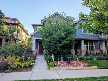 Charming two-story home with landscaped yard, garden, bird bath, and inviting front porch at 1145 S Logan St, Denver, CO 80210