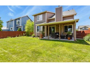 Expansive backyard with lush green lawn, covered patio area perfect for outdoor entertaining at 13235 Clermont Cir, Thornton, CO 80241