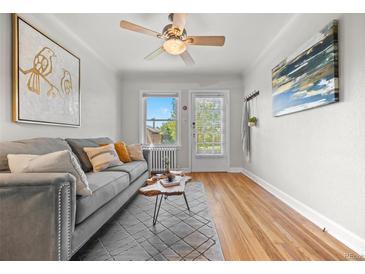 Bright living room with hardwood floors, a ceiling fan, modern furnishings, and abundant natural light at 2616 Utica St, Denver, CO 80212
