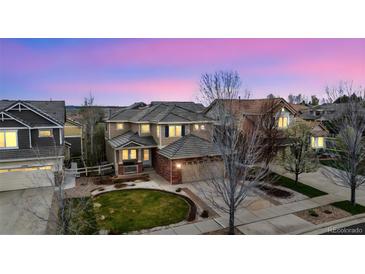 Stunning home featuring an eye-catching lawn, mature trees, and a welcoming entrance at 12850 Ventana St, Parker, CO 80134