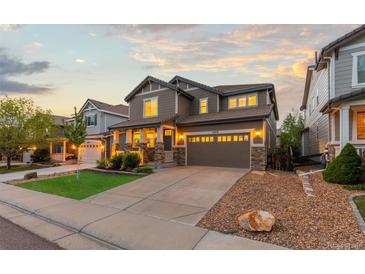 Beautiful two-story home with a well-maintained lawn, stone accents, and a two-car garage at 14278 Greenfield Loop, Parker, CO 80134