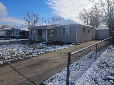 Charming single-story home with a well-maintained lawn and private driveway on a partially cloudy day at 4720 Thompson Ct, Denver, CO 80216