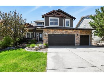 Charming two-story home featuring a stone facade and a spacious three-car garage at 7243 S Kellerman Way, Aurora, CO 80016