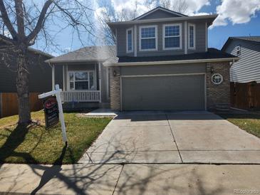 Two-story home featuring a two-car garage, covered porch, and well-maintained landscaping at 5256 E 129Th Pl, Thornton, CO 80241