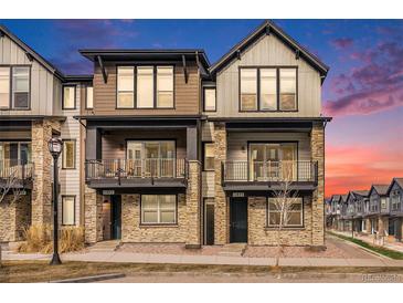 Modern townhome exterior showcasing stone accents, dual balconies, and contemporary design elements at 11873 W 51St Ave, Wheat Ridge, CO 80033