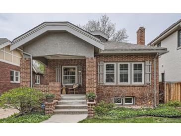 Charming brick home featuring a covered front porch with seating area at 1023 S High St, Denver, CO 80209