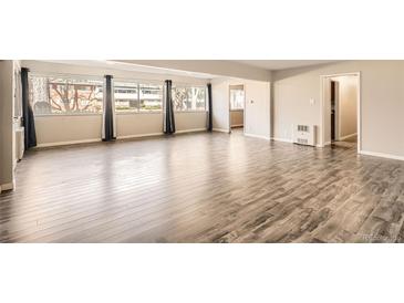 Bright living room with hardwood floors, large windows, and elegant curtains at 2201 S Holly St # 1, Denver, CO 80222