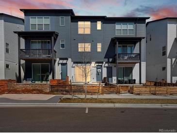 Modern townhouse with blue-gray siding, balconies, and well-maintained landscaping creates appealing curb appeal at 2721 W 167Th Pl, Broomfield, CO 80023