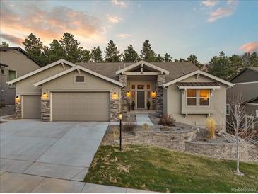 Charming single-Gathering home featuring stone accents, a well-maintained yard, and an attached two-car garage at 16113 Enchanted Peak Way, Monument, CO 80132