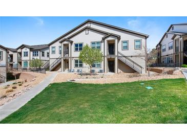 Inviting townhouse with a well-maintained lawn and exterior stairs leading to the entrance at 4500 Copeland Cir # 104, Highlands Ranch, CO 80126