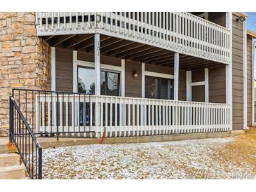 Exterior shot of a brown condo building with white railing on the balconies and stone facade at 18004 E Ohio Ave # 101, Aurora, CO 80017