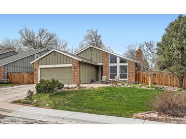 Charming home with a brick exterior, well-kept lawn, large windows, and a cozy front patio at 8101 S San Juan Range Rd, Littleton, CO 80127