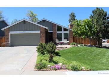 Charming brick home with a well-manicured lawn, flower beds, and an attached two-car garage at 8101 S San Juan Range Rd, Littleton, CO 80127