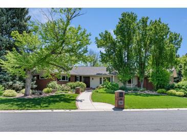 Charming single-story home featuring a brick exterior, lush landscaping, and a welcoming walkway at 3980 S Dexter St, Cherry Hills Village, CO 80113