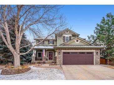 Charming two-story home features a covered porch, stone accents, and a two-car garage at 9882 S Hoyt Ct, Littleton, CO 80127