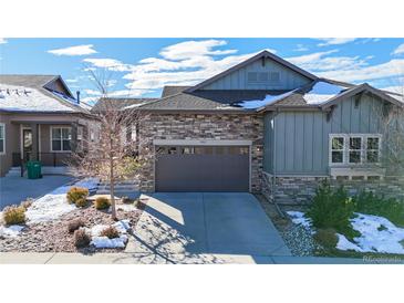 Charming home featuring a stone and siding exterior, complemented by a two-car garage and well-maintained landscaping at 3565 New Haven Cir, Castle Rock, CO 80109