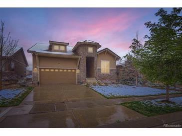 Charming home featuring a stone archway, two-car garage, and well-maintained landscaping at 15855 Wild Horse Dr, Broomfield, CO 80023
