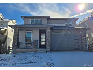 Charming two-story home featuring stone accents, a covered porch, and an attached garage at 8816 Whiteclover St, Littleton, CO 80125