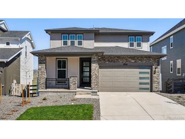 Charming two-story home with stone accents and a well-maintained front yard and modern garage at 8816 Whiteclover St, Littleton, CO 80125