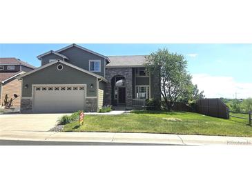 Beautiful two-story home with stone accents, a two-car garage, and a well-manicured front lawn at 21580 Longs Peak Ln, Parker, CO 80138
