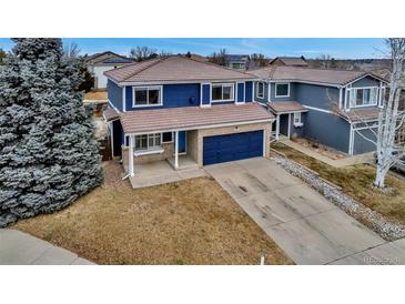 Beautiful two-story home with a blue exterior, covered porch, tile roof, and a spacious driveway at 4539 Lyndenwood Cir, Highlands Ranch, CO 80130