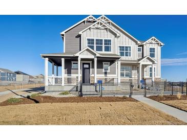 Charming two-story home with a covered porch, a fenced yard, and stylish architectural details at 924 Andrews Crest Dr, Berthoud, CO 80513