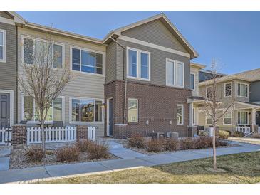Charming two-story townhome with brick accents, inviting entrance and manicured lawn at 15530 W 64Th Pl # C, Arvada, CO 80007