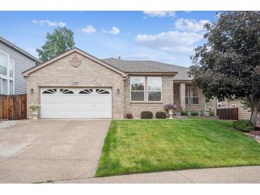 Charming brick home with a well-manicured lawn and attached two car garage at 11237 W Ford Dr, Lakewood, CO 80226