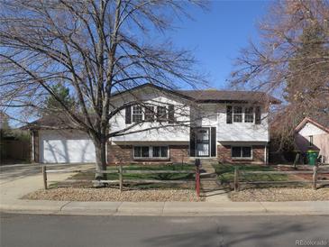 Charming two-story home with a brick-accented facade and a well-maintained front yard at 827 Hannibal Dr, Aurora, CO 80011