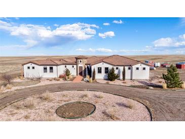 Elegant single-story home with a tile roof, circular driveway, and desert landscaping at 7172 S Oakleaf St, Bennett, CO 80102