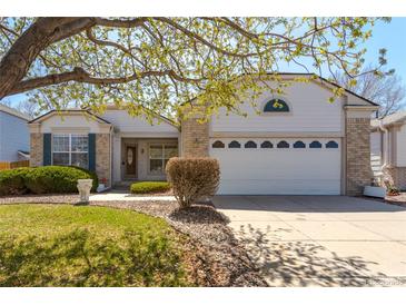 Charming home featuring a brick and siding exterior, well-kept lawn, and a two-car garage at 4428 S Kalispell Cir, Aurora, CO 80015