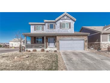 Charming two-story home featuring a welcoming front porch, stone accents, and a well-maintained lawn at 13903 Hillsboro Dr, Parker, CO 80134