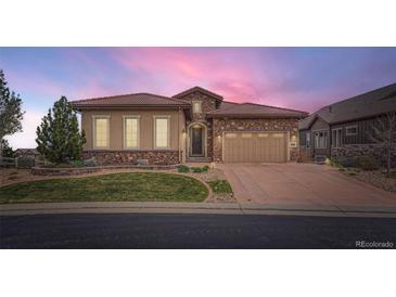 Beautiful single Gathering home featuring a stone and stucco exterior with a meticulously maintained front yard at 10646 Winding Pine Pt, Highlands Ranch, CO 80126