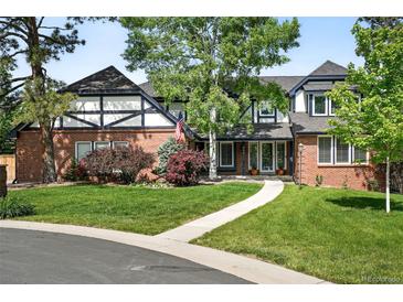 Charming brick Tudor-style home featuring well-manicured landscaping and a welcoming entrance at 5441 S Dayton Ct, Greenwood Village, CO 80111