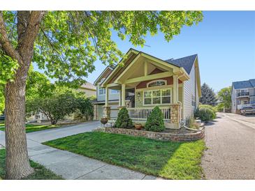 Charming home featuring a well-maintained lawn and a welcoming front porch with stone accents and a manicured garden at 301 Harvest St, Longmont, CO 80501