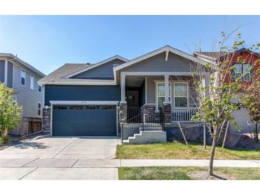 Charming two-story home with a covered porch, well-maintained lawn, and an attached two-car garage at 20936 E 61St Ave, Aurora, CO 80019