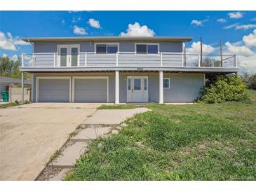 Two-story home featuring a balcony, three-car garage, and well-maintained lawn at 15805 W 14Th Pl, Golden, CO 80401