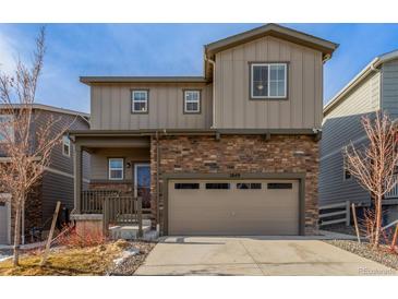 Inviting two-story home with a stone facade, covered porch, and a two-car garage, perfect for modern living at 1849 Village View Ln, Castle Rock, CO 80104