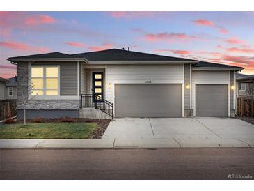 Charming single-story home with a two-car garage and well-manicured front lawn, showcasing modern curb appeal at 4063 Castle Vista Dr, Castle Rock, CO 80104